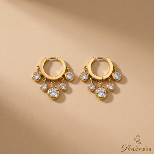 Pair of clear zirconia charm huggie earrings made of gold-plated stainless steel.