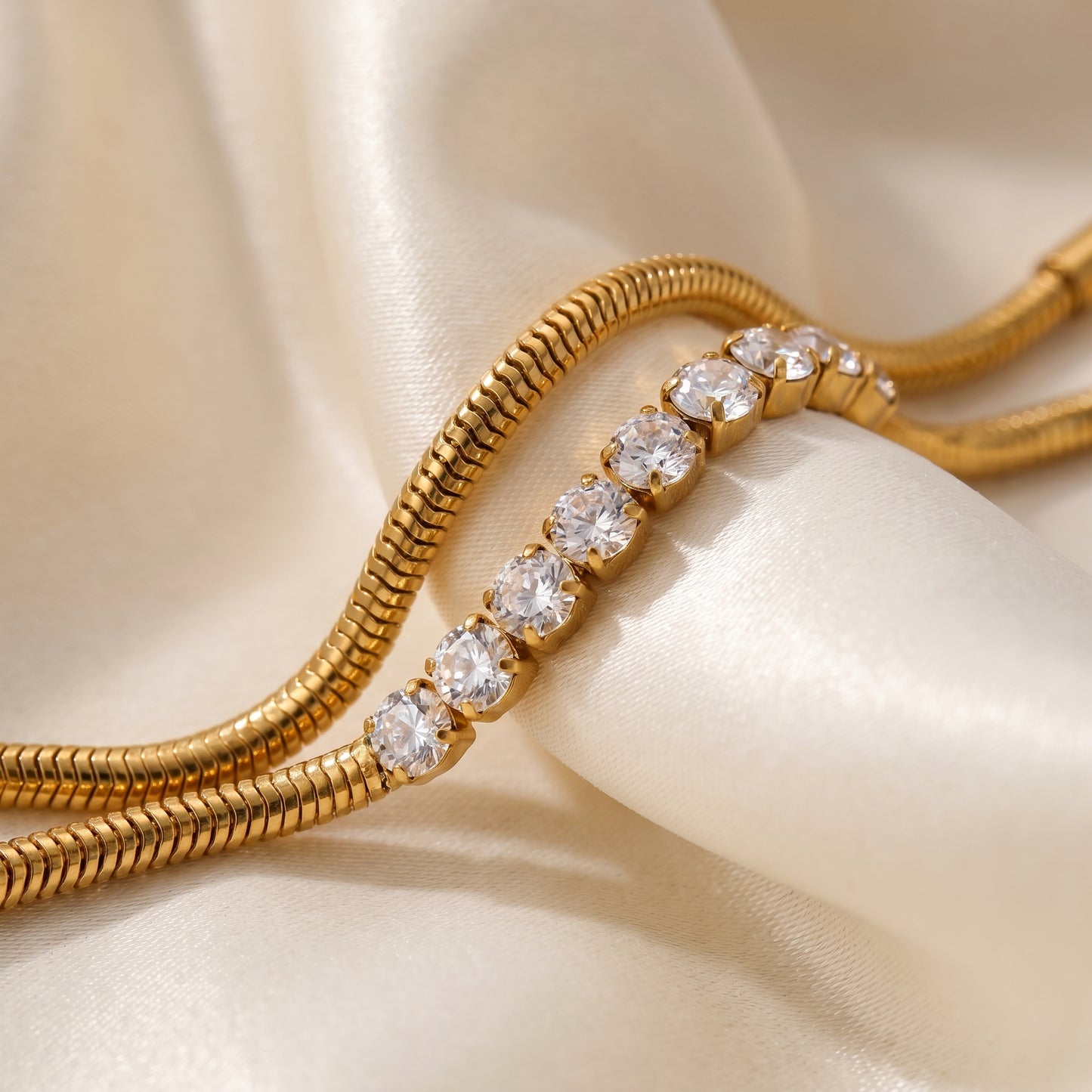 Gold bracelet with diamond accents on a beige fabric background
