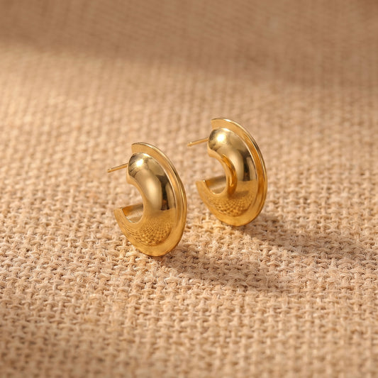 Sleek, high quality Vesper Arch gold dome hoops shown side-by-side on a reflective background, highlighting their brilliant waterproof gold plating.
