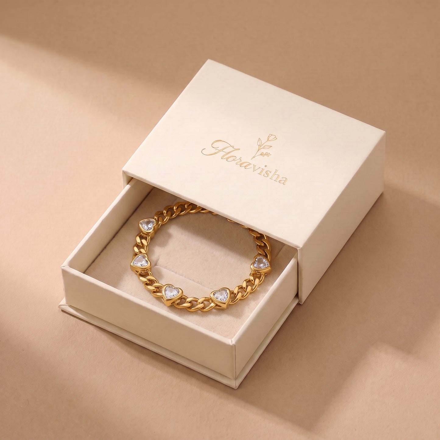 High quality Amour gold heart crystal curb chain bracelet displayed inside an off-white Floravisha luxury sliding jewelry gift box.