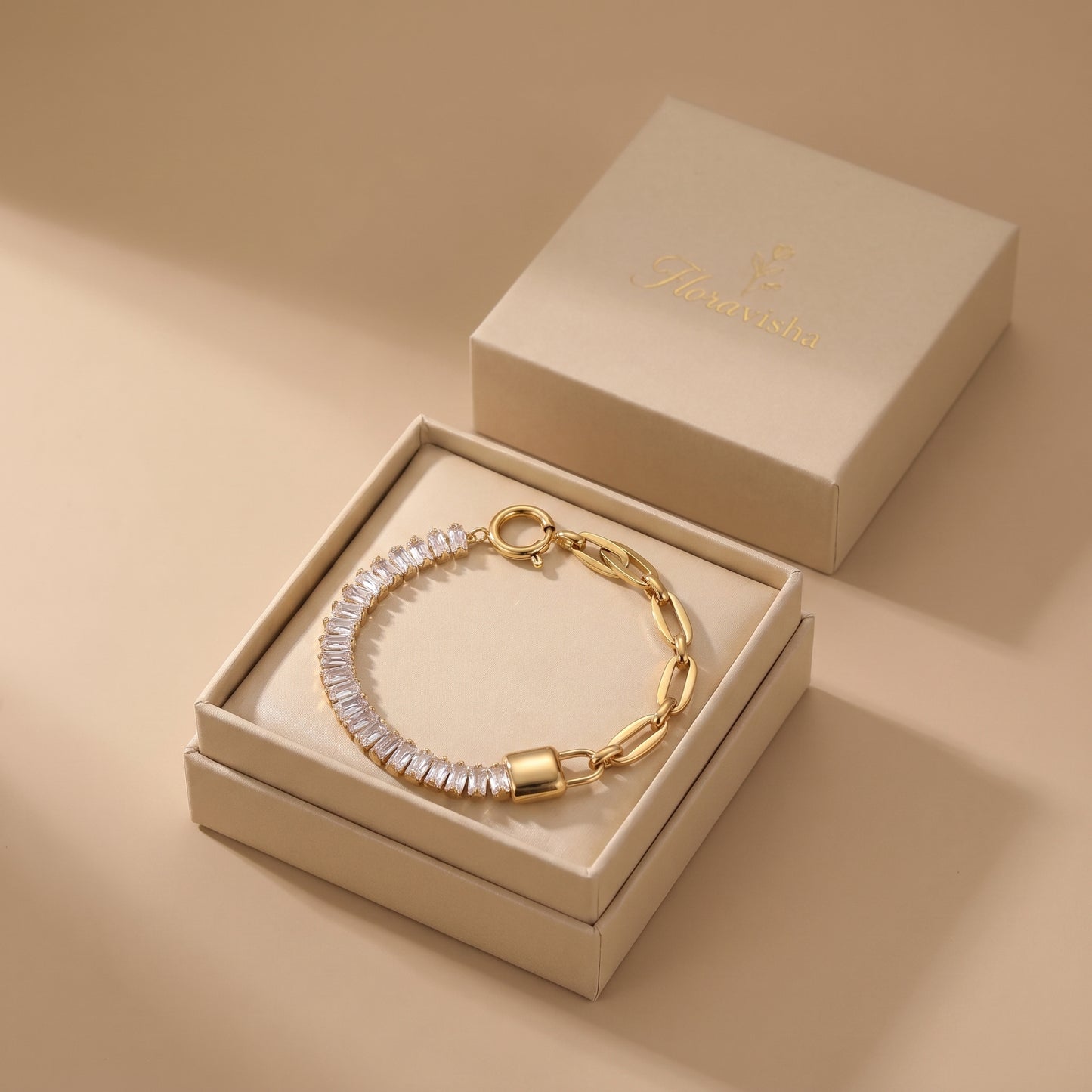 High quality Elysée gold baguette paperclip lock bracelet presented inside an off-white Floravisha luxury sliding jewelry gift box.