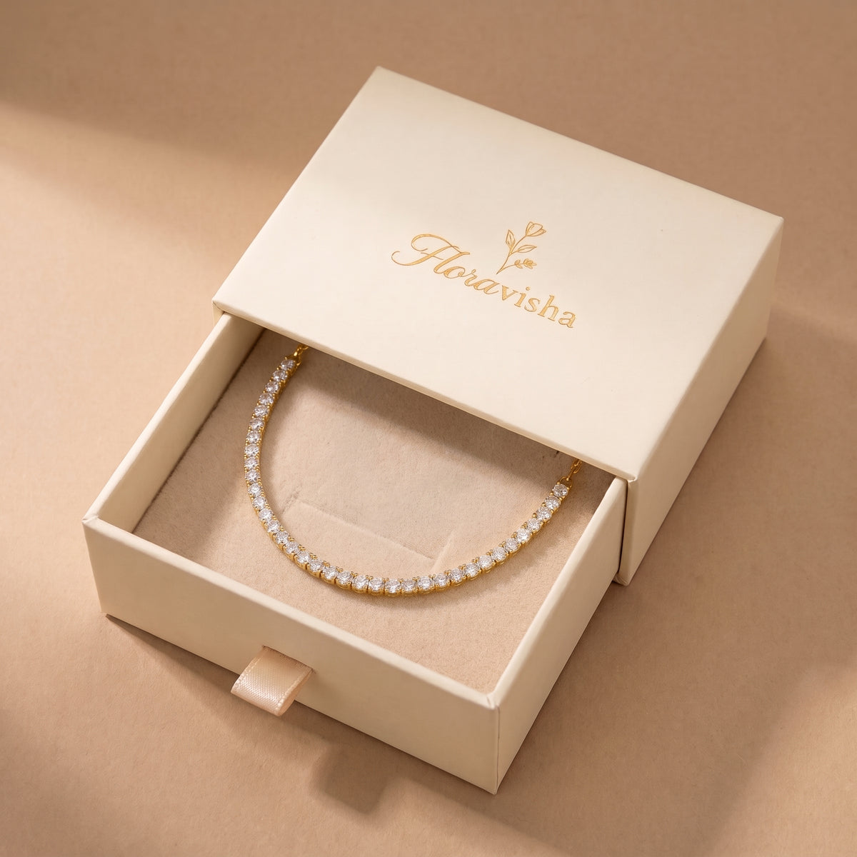 Waterproof Étoile gold half tennis crystal choker resting on a velvet pillow inside an open off-white Floravisha luxury sliding jewelry gift box.