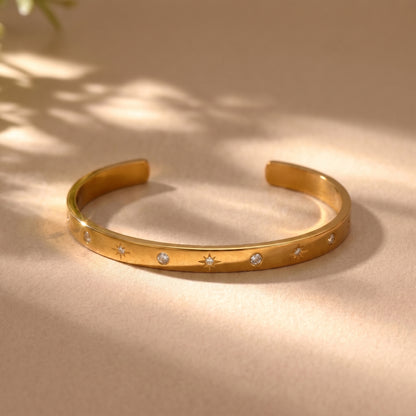 Sleek gold Aria Bangle featuring channel-set clear baguette crystals on a clean background, highlighting its tarnish-free and skin friendly finish.