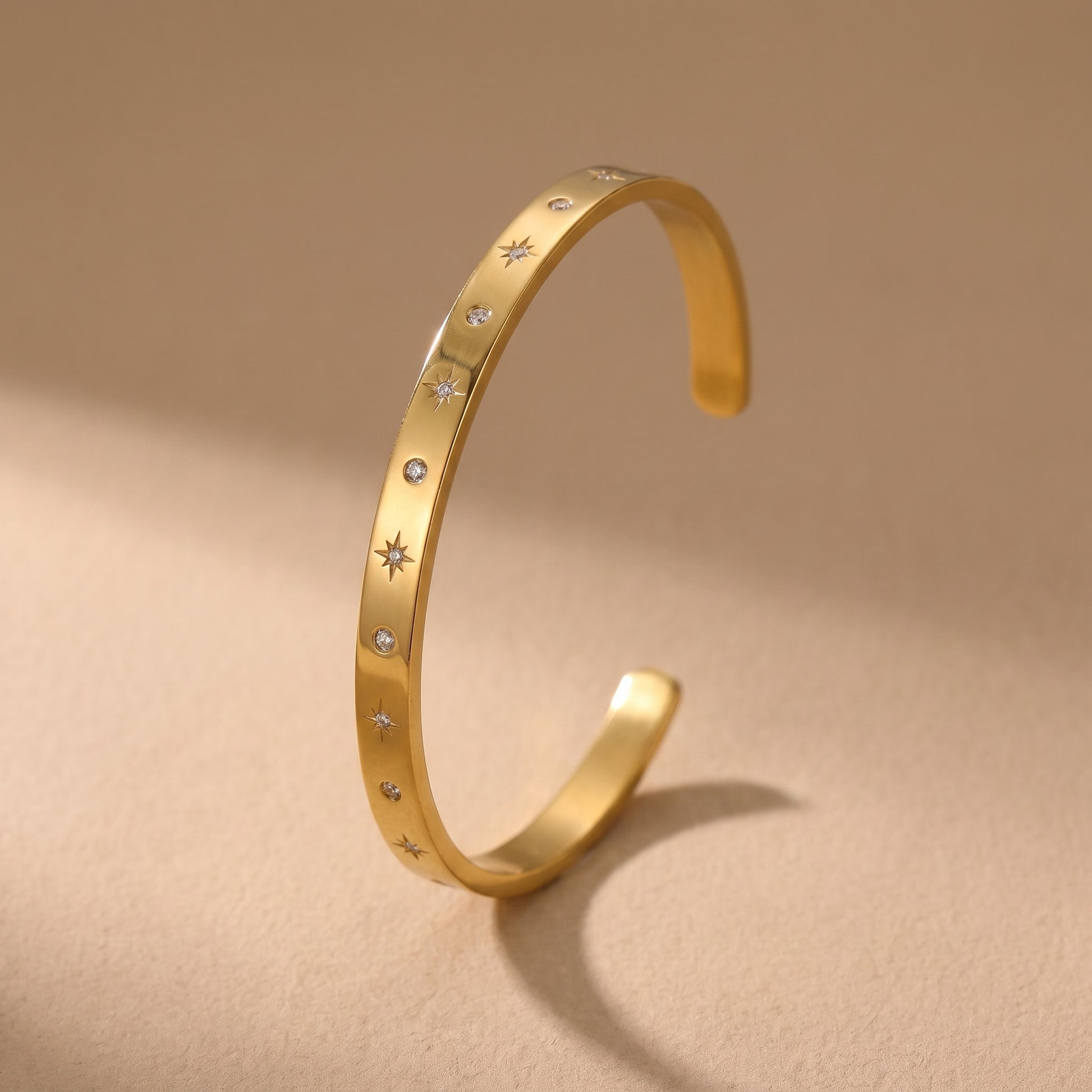 Sleek gold Aria Bangle featuring channel-set clear baguette crystals on a clean background, highlighting its tarnish-free and skin friendly finish.