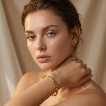 Woman wearing high quality Aura Minimalist Cuff Bangle by Floravisha against a beige background