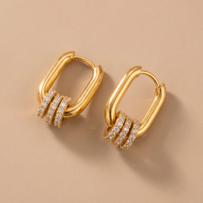 The tarnish-free gold Aurelia Eternity Hoops showing a pair of elongated rectangular huggies with three sliding crystal pavé charms
