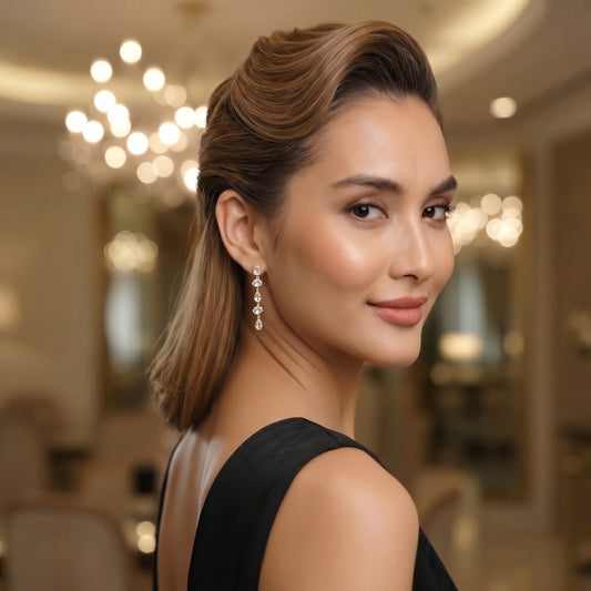 Woman in a black dress with elegant earrings in an indoor setting