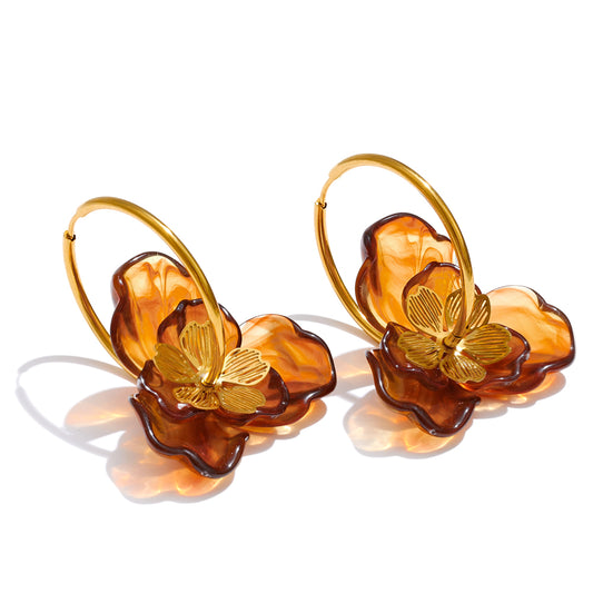 Pair of earrings with gold butterfly details and brown flower shapes on a white background. latest earring models and trending earrings models. new arrivals.