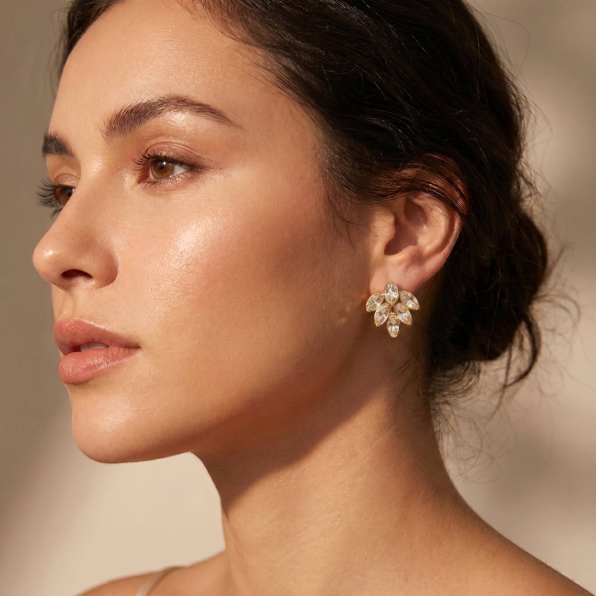 Close-up of a woman wearing High quality waterproof gold plated stud earrings featuring a modern fan design with clear marquise-cut crystals.