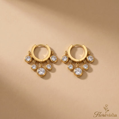 Pair of clear zirconia charm huggie earrings made of gold-plated stainless steel.