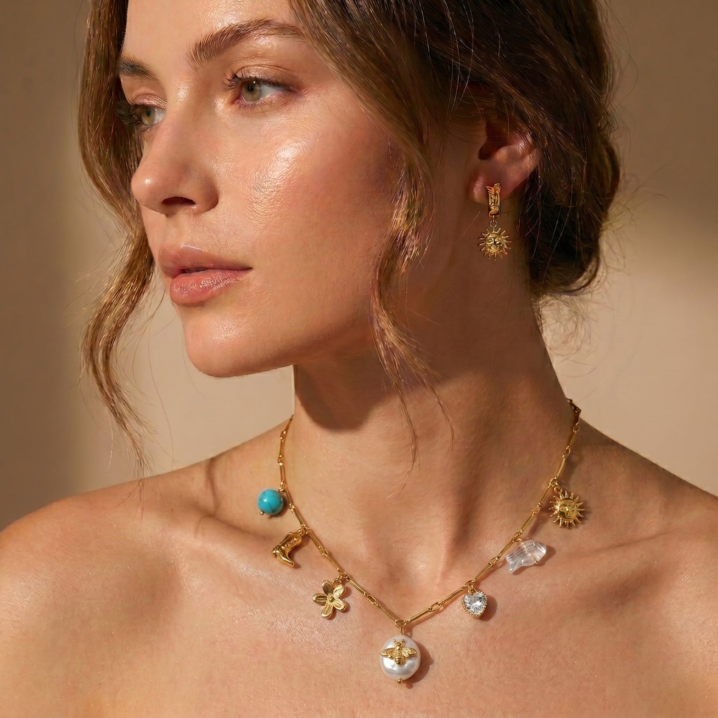 High quality waterproof gold plated charm necklace featuring eclectic pendants including a sun, cowboy boot, bee on a pearl, and a crystal heart.
