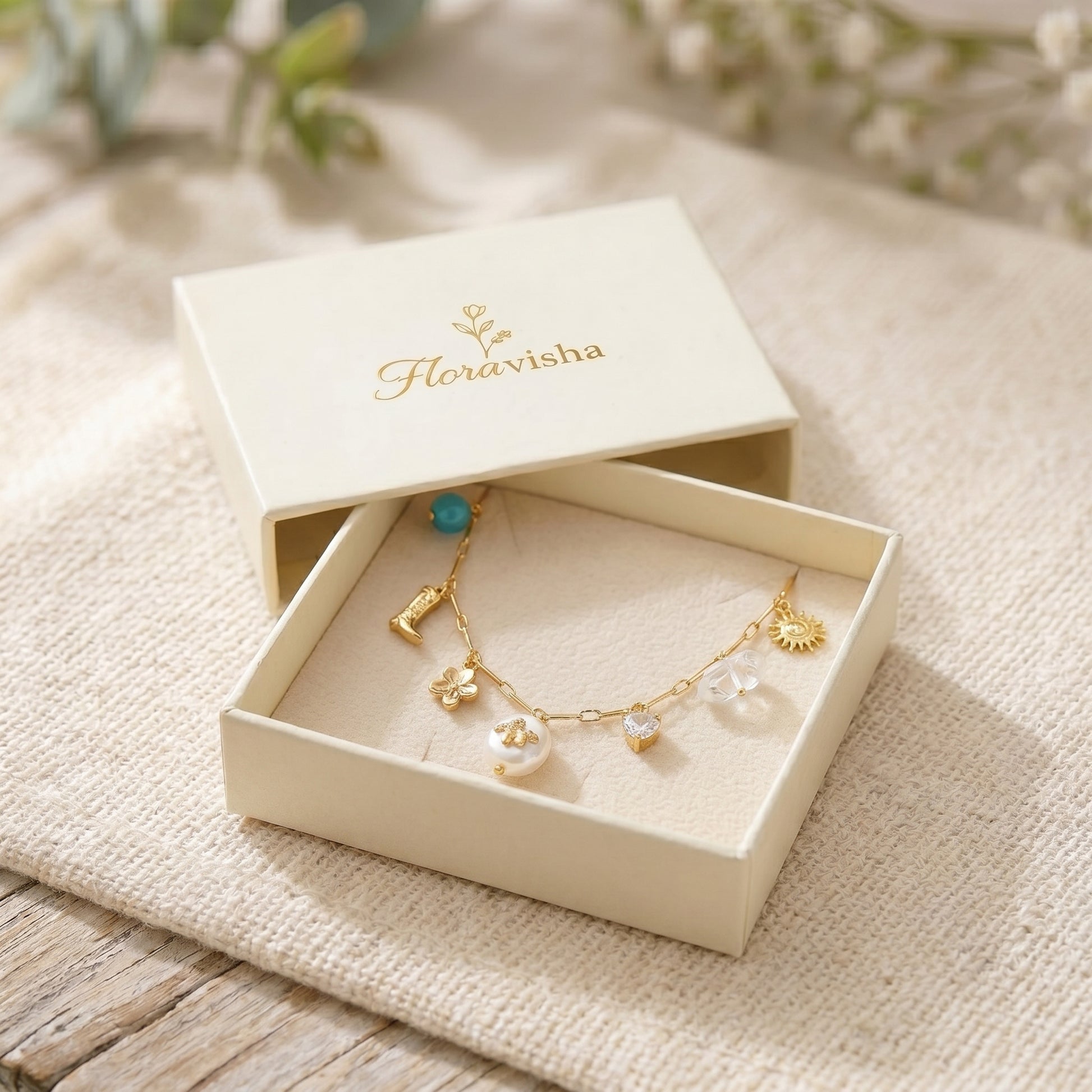 Jewelry box with a gold necklace featuring pendants on a textured surface.