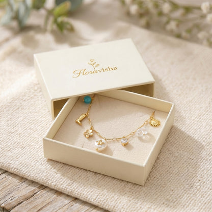 Jewelry box with a gold necklace featuring pendants on a textured surface.