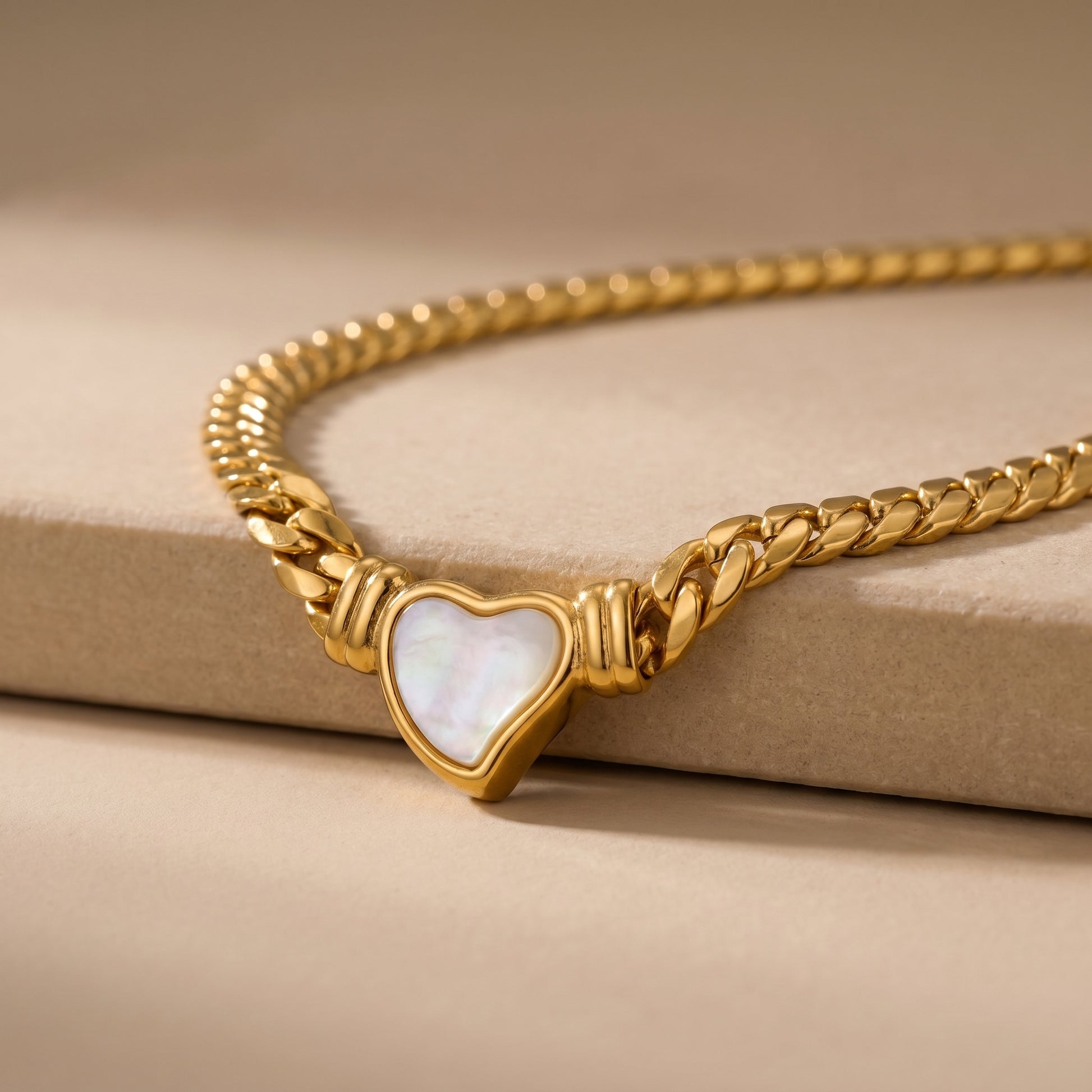 close-up of gold snake chain necklace with heart charm pendant modern jewelry