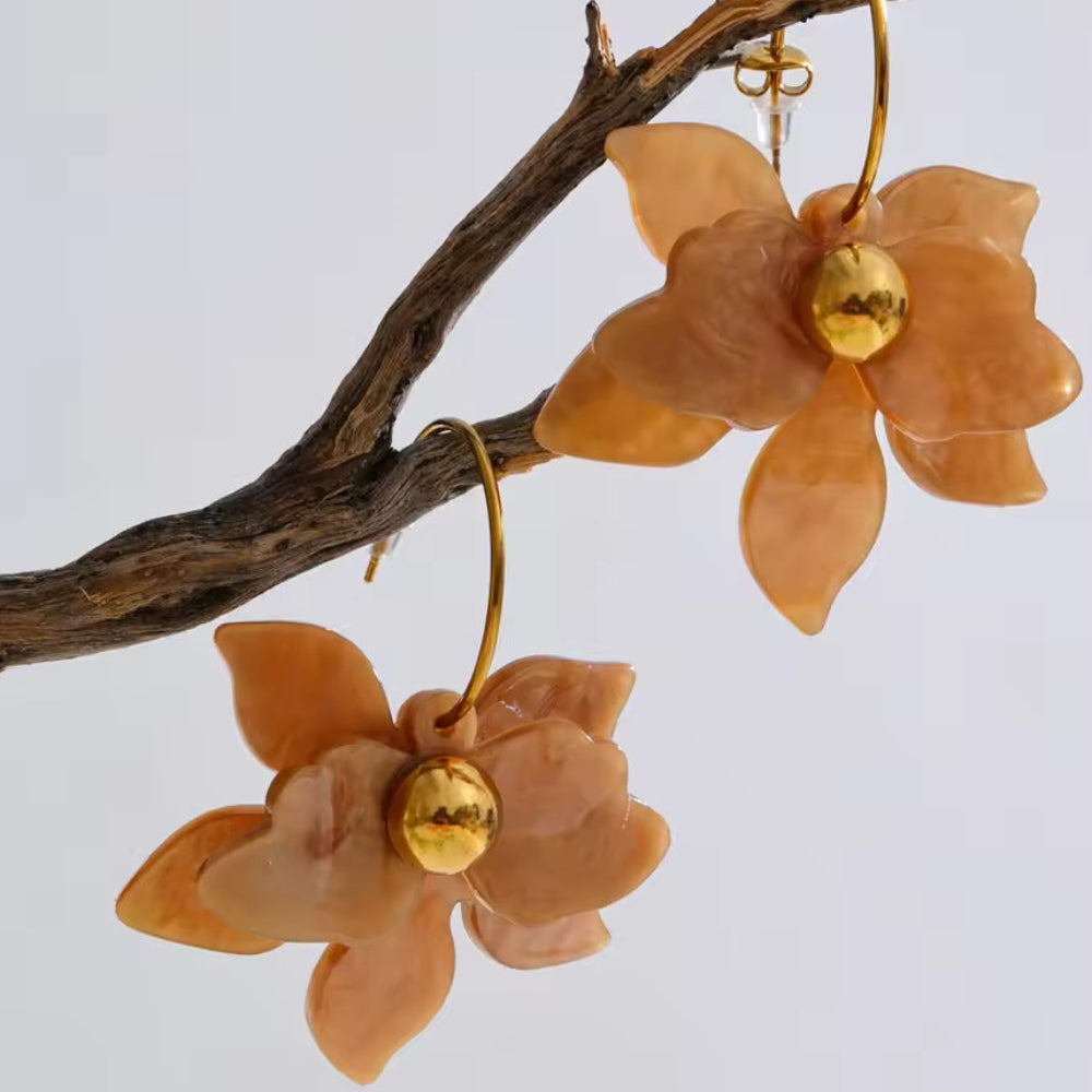 Floral earrings with gold centers on a branch against a light background. latest earring models and trending earrings models. new arrivals.