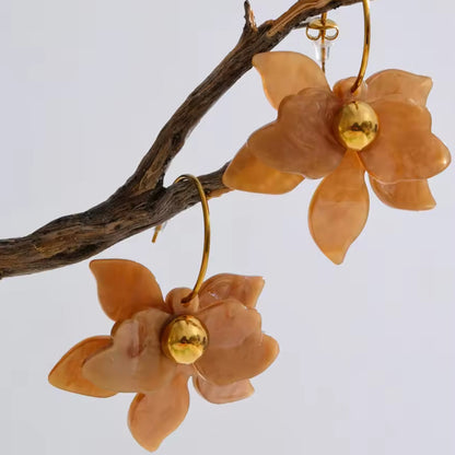 Floral earrings with gold centers on a branch against a light background. latest earring models and trending earrings models. new arrivals.