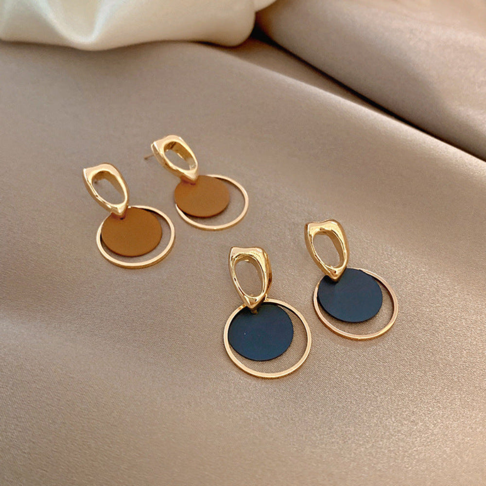 Gold and black earrings on a beige fabric background.  latest earring models and trending earrings models. new arrivals.