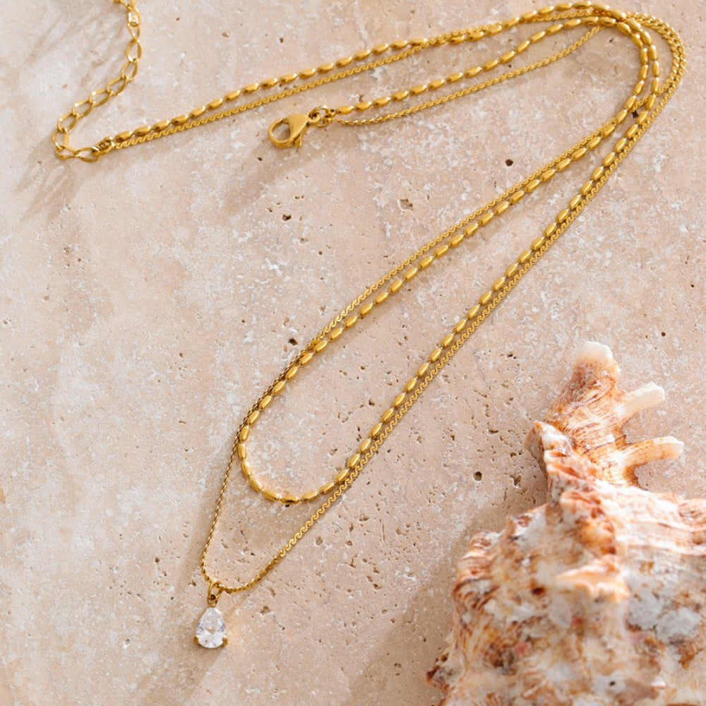Gold layered necklace with a pendant.