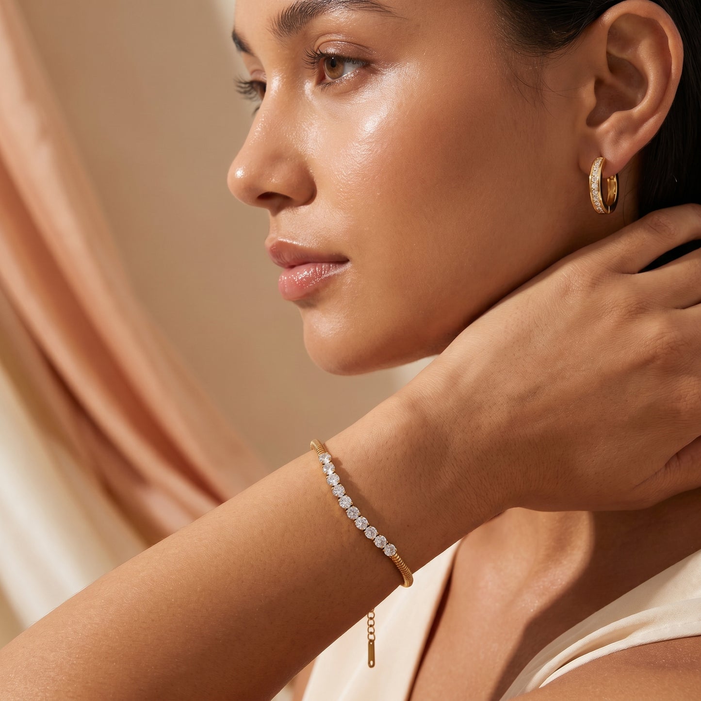Woman wearingHigh quality waterproof gold plated snake chain bracelet featuring a row of clear crystals against a neutral background.