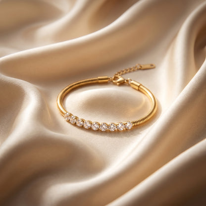 Gold bracelet with diamonds on a beige satin background
