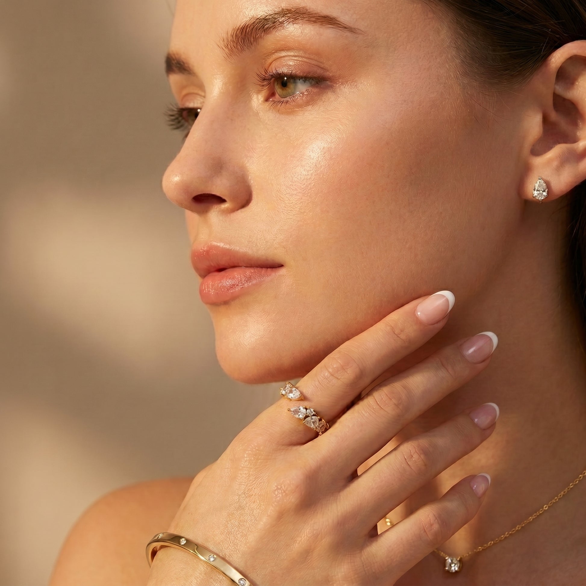 Close-up of a woman wearing Aurora Crystal Cluster Adjustable Ring by Floravisha. A high-quality, waterproof gold-plated open wrap ring featuring an elegant, asymmetrical botanical cluster of teardrop and round clear crystals. Tarnish-free and skin-friendly.