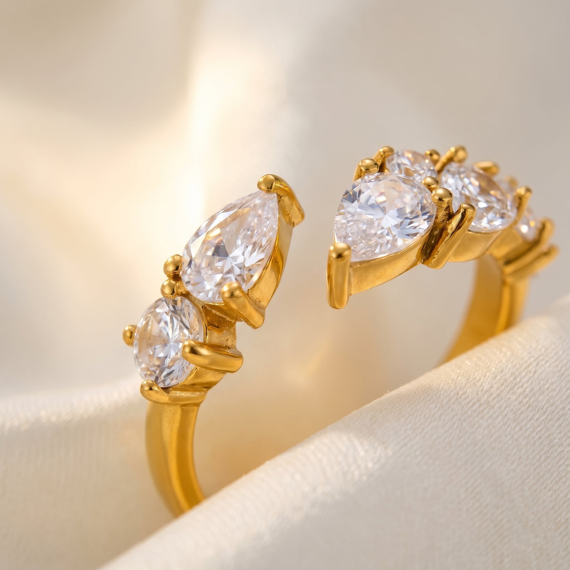 Aurora Crystal Cluster Adjustable Ring by Floravisha. A high-quality, waterproof gold-plated open wrap ring featuring an elegant, asymmetrical botanical cluster of teardrop and round clear crystals. Tarnish-free and skin-friendly on a soft beige background.