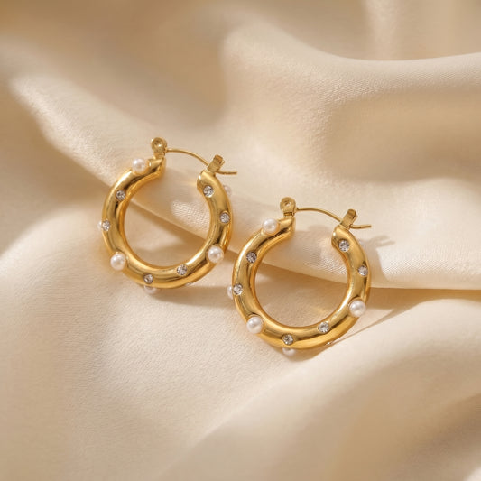 High quality waterproof gold plated chunky hoop earrings featuring scattered pearls and inset crystals, laid flat on a pristin background