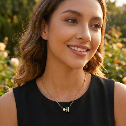 Woman wearing a necklace with a green pendant outdoors