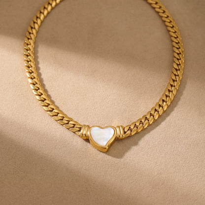 gold snake chain heart pendant necklace on neutral background minimalist luxury jewelry