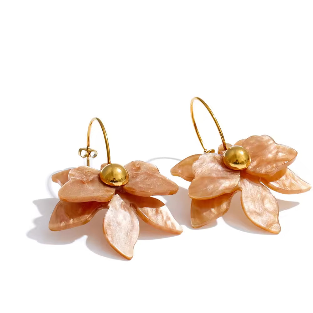 Pair of peach-colored flower-shaped earrings with gold centers on a white background. latest earring models and trending earrings models. new arrivals.