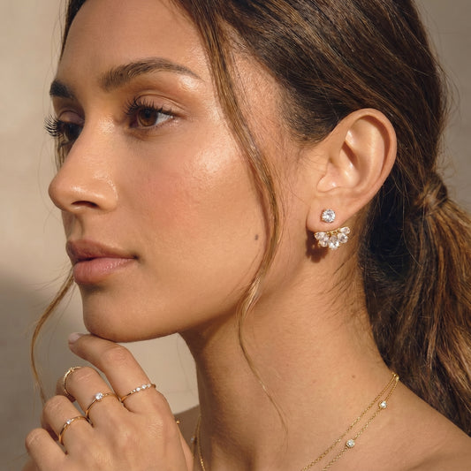 High quality waterproof gold plated 2-in-1 convertible fan earrings featuring a round solitaire stud and an interchangeable fanned crescent of clear crystals worn by a women.