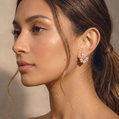 High quality waterproof gold plated 2-in-1 convertible fan earrings featuring a round solitaire stud and an interchangeable fanned crescent of clear crystals worn by a women.