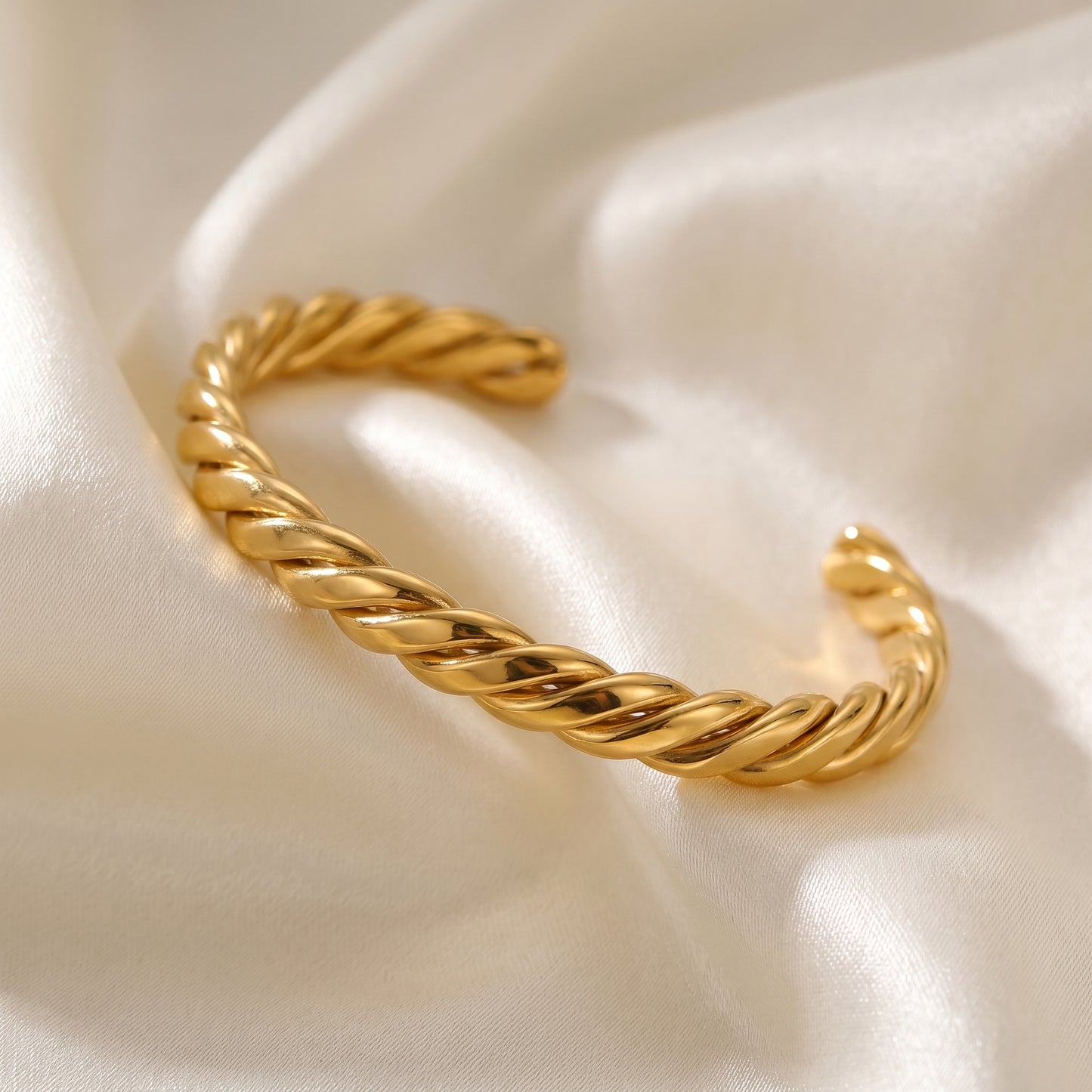 High quality Sienne Twisted Cuff Bangle by Floravisha on a satin surface.