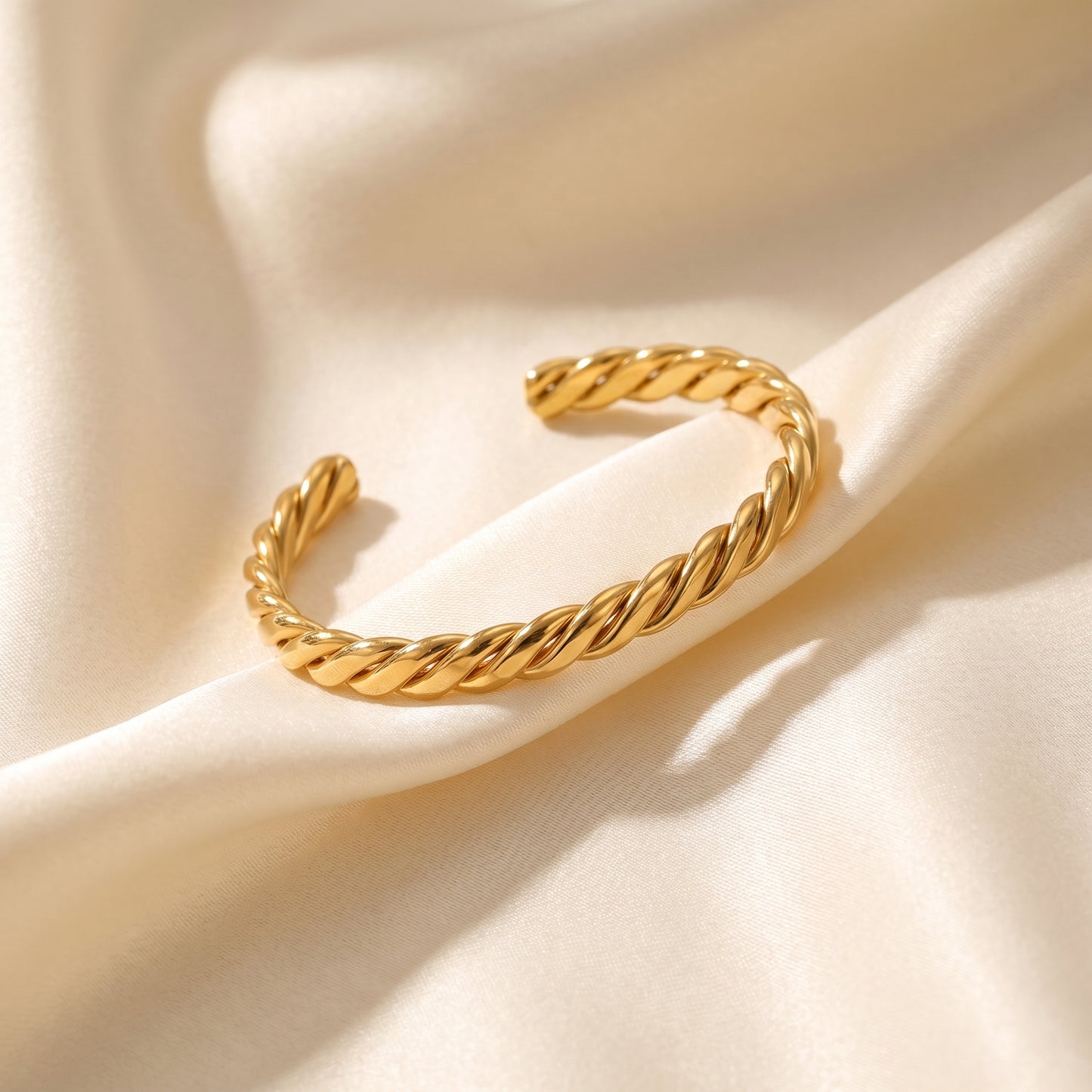 high quality Sienne Twisted Cuff Bangle by Floravisha on a beige fabric background.