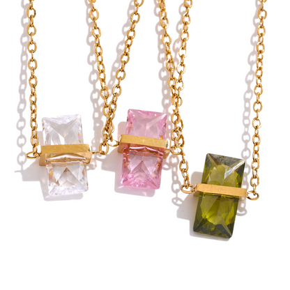Three gold necklaces with colorful gemstone pendants.