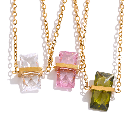 Three gold necklaces with colorful gemstone pendants.