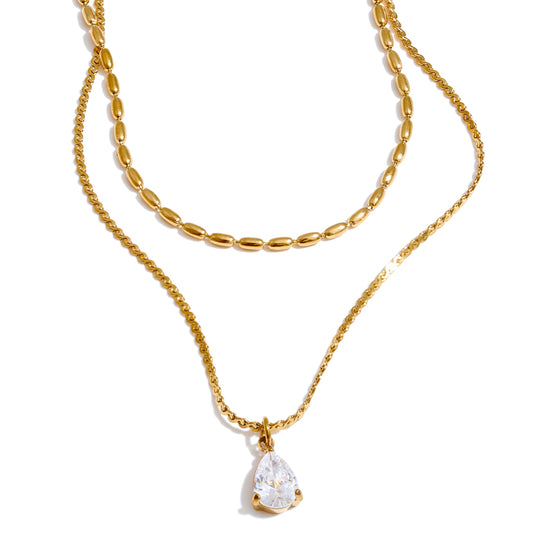 Gold layered necklace with a pendant.