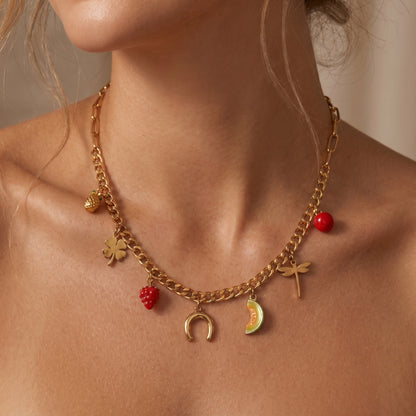 Sleek Verona gold fruit charm necklace styled on a model's collarbone to show how the mixed paperclip and curb chain drapes.