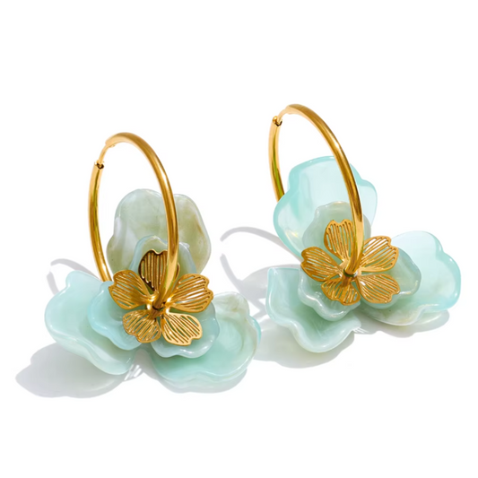 Pair of earrings with gold butterfly details and light blue flower shapes on a white background. latest earring models and trending earrings models. new arrivals.