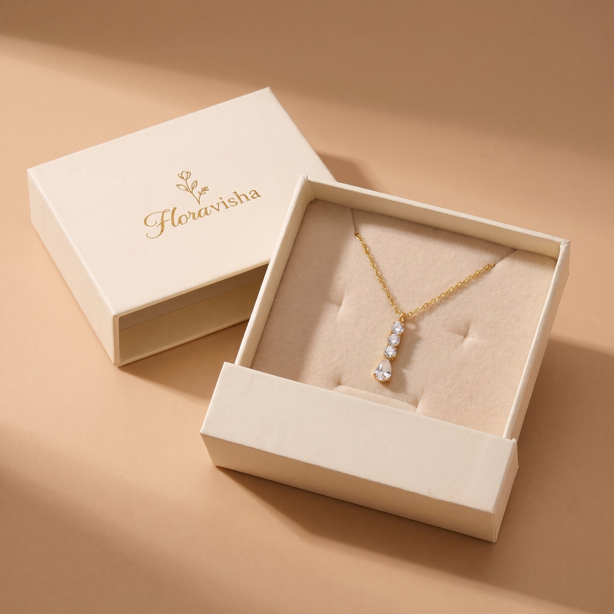 High quality Camille gold linear crystal drop necklace presented on a plush velvet pillow inside an off-white Floravisha luxury sliding jewelry gift box.