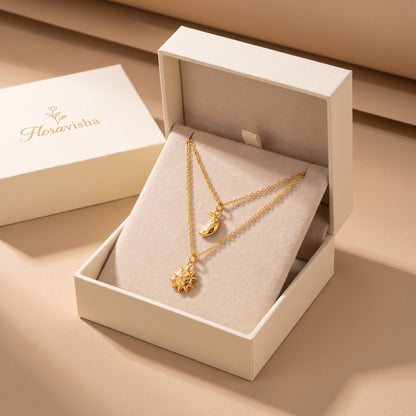 High quality Céleste gold layered sun and moon pendant necklace displayed inside an off-white Floravisha luxury sliding jewelry gift box.