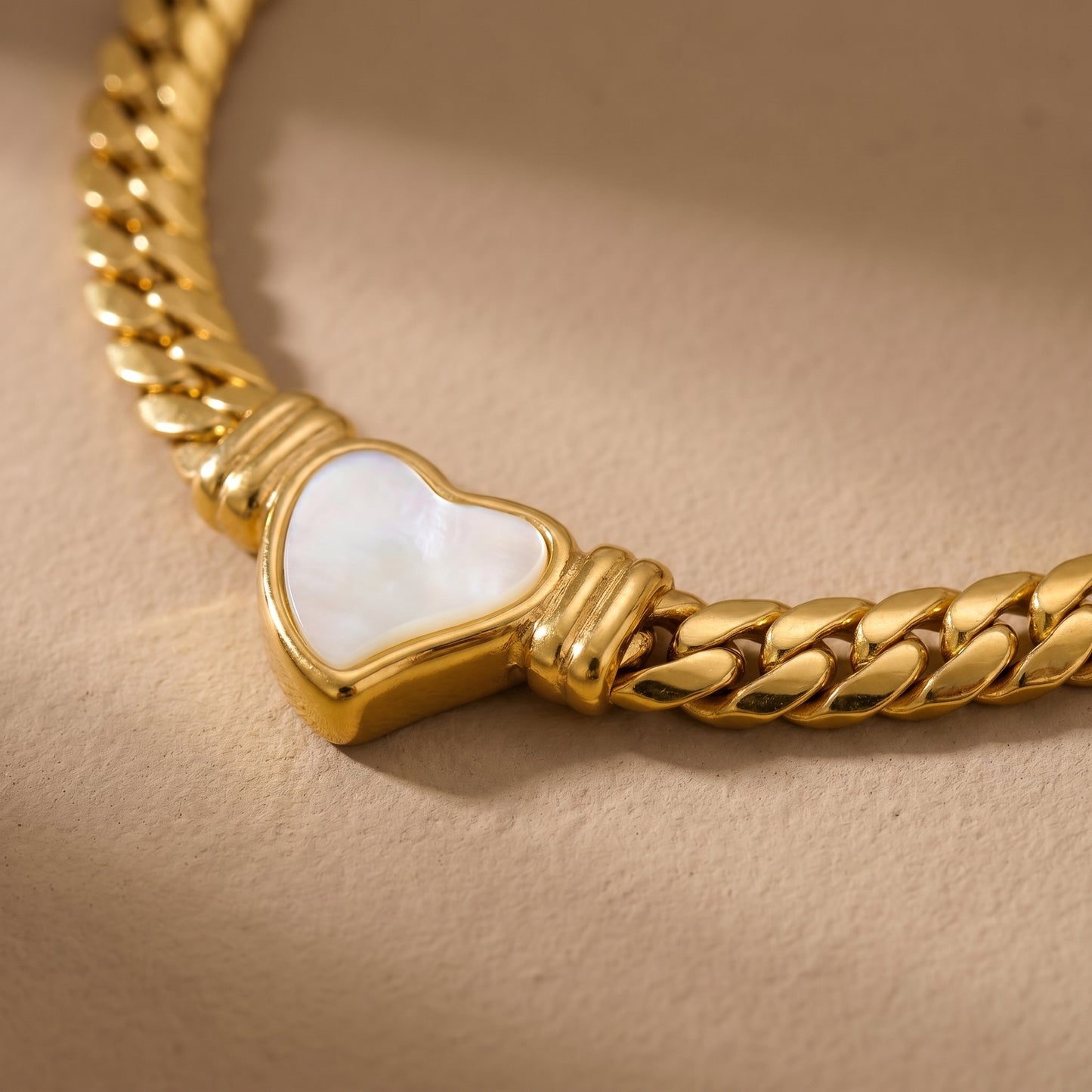 close-up of gold snake chain necklace with heart charm pendant modern jewelry