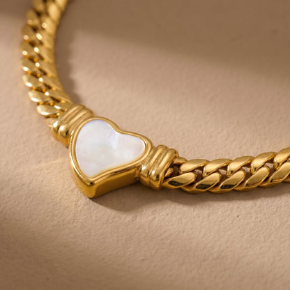 close-up of gold snake chain necklace with heart charm pendant modern jewelry