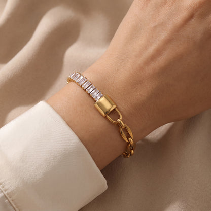 Close-up view of a woman's wrist wearing the waterproof Elysée gold asymmetric paperclip lock bracelet in warm natural lighting.