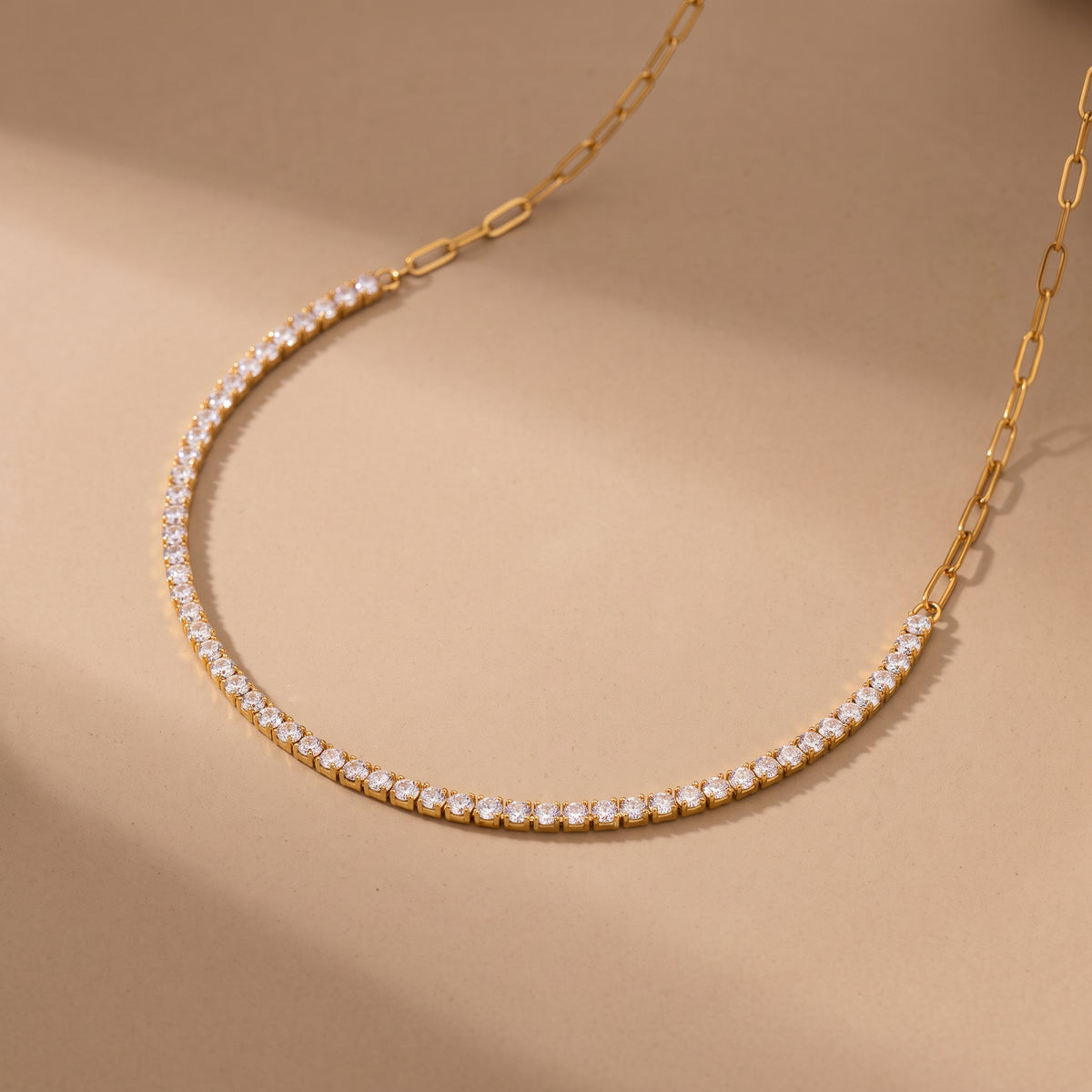 Macro close-up view of the tarnish-free Étoile gold choker showing the seamless transition between prong-set round crystals and elongated paperclip links.