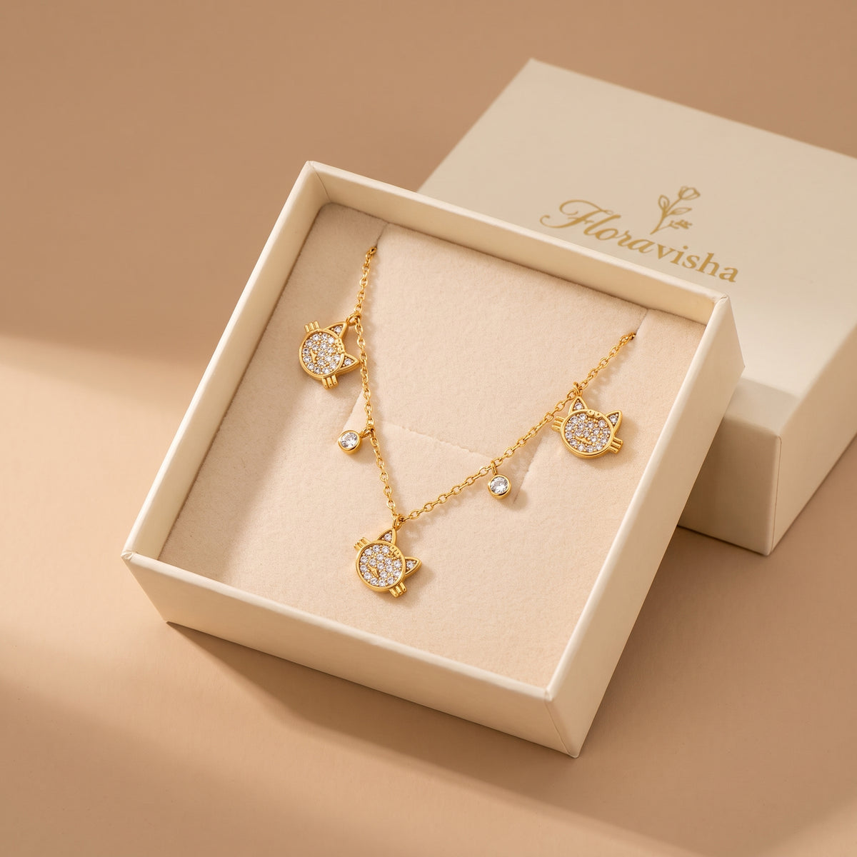 Waterproof Féline gold pavé cat necklace resting on a velvet pillow inside an open off-white Floravisha luxury sliding jewelry gift box.