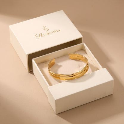 High quality Ondine gold double-layered wave open cuff bangle presented inside an off-white Floravisha luxury sliding jewelry gift box.