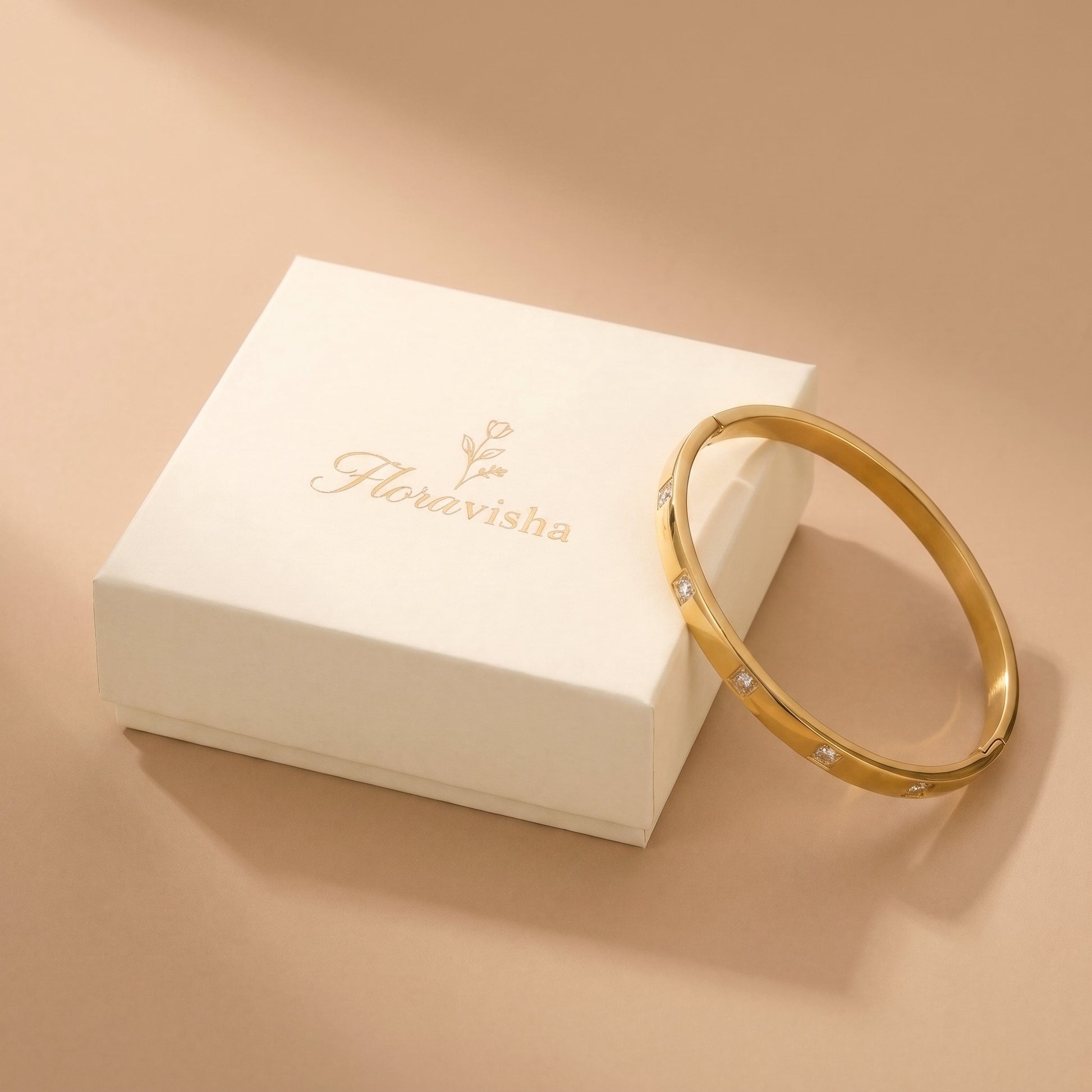 Waterproof Solene gold flush-set crystal bracelet resting beside an elegant off-white Floravisha branded luxury jewelry gift box.