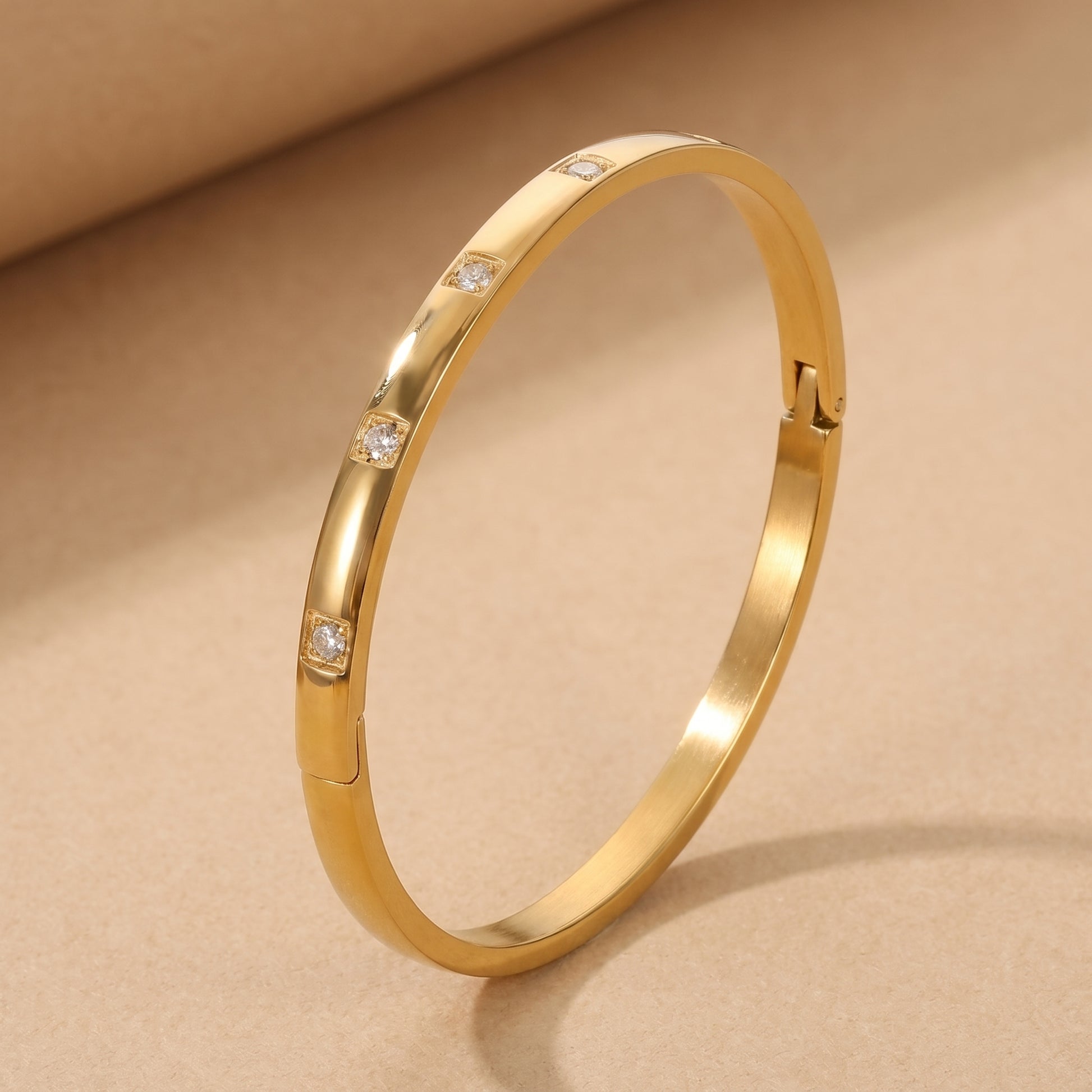 High quality Solene Gold Bracelet by Floravisha featuring flush-set clear cubic zirconia crystals resting on a warm beige surface in natural sunlight.