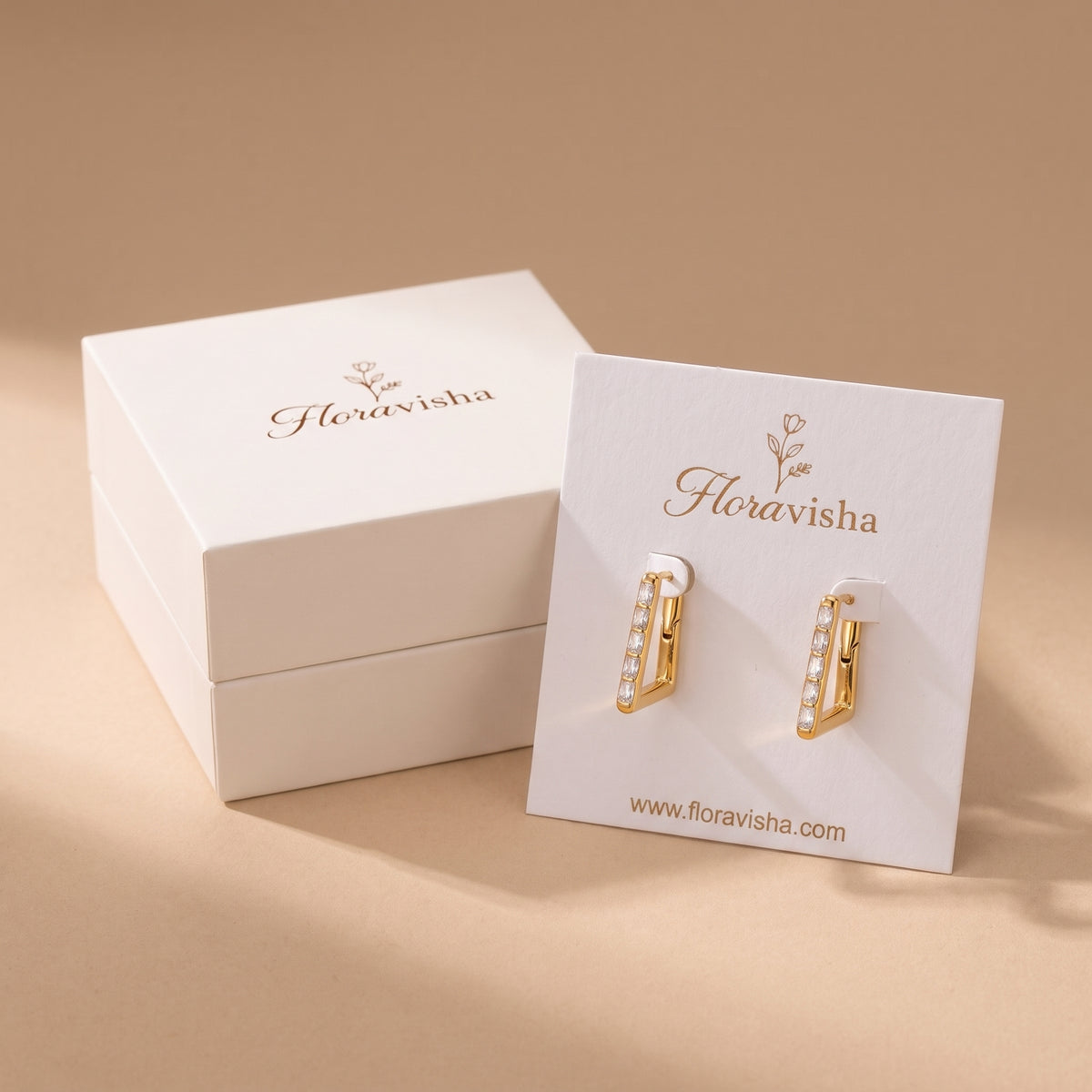High quality Vendôme gold geometric baguette hoop earrings mounted on an elegant Floravisha jewelry card next to an off-white luxury gift box.